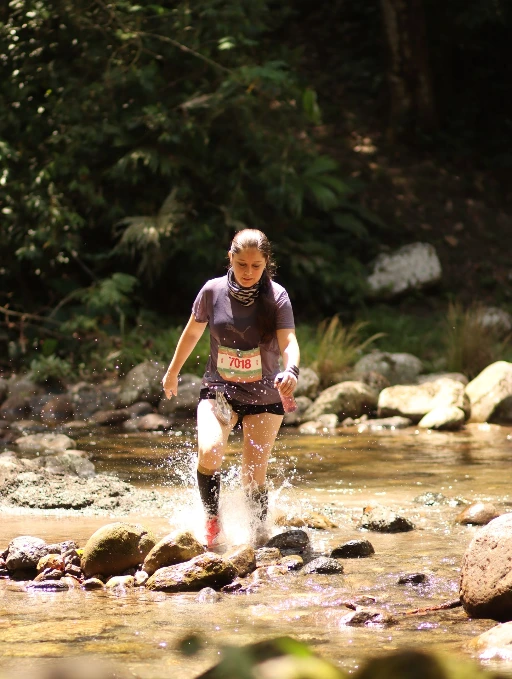 Corredora cruzando una quebrada en el Alto Shilcayo Trail, Tarapoto