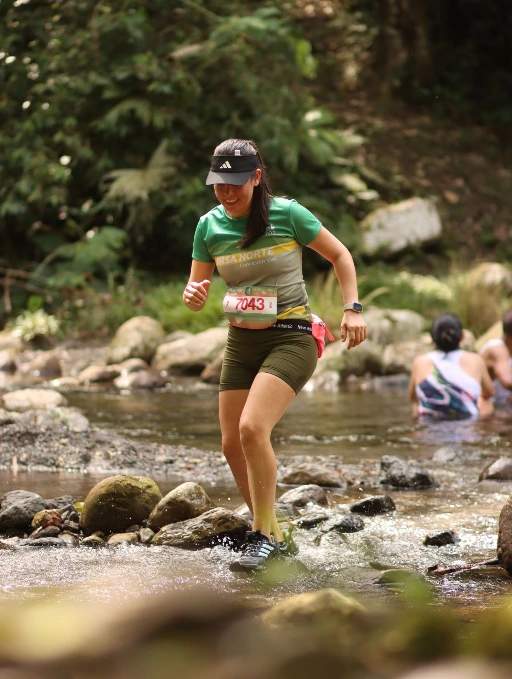 Corredora cruzando una quebrada durante el Alto Shilcayo Trail 2026 en Tarapoto