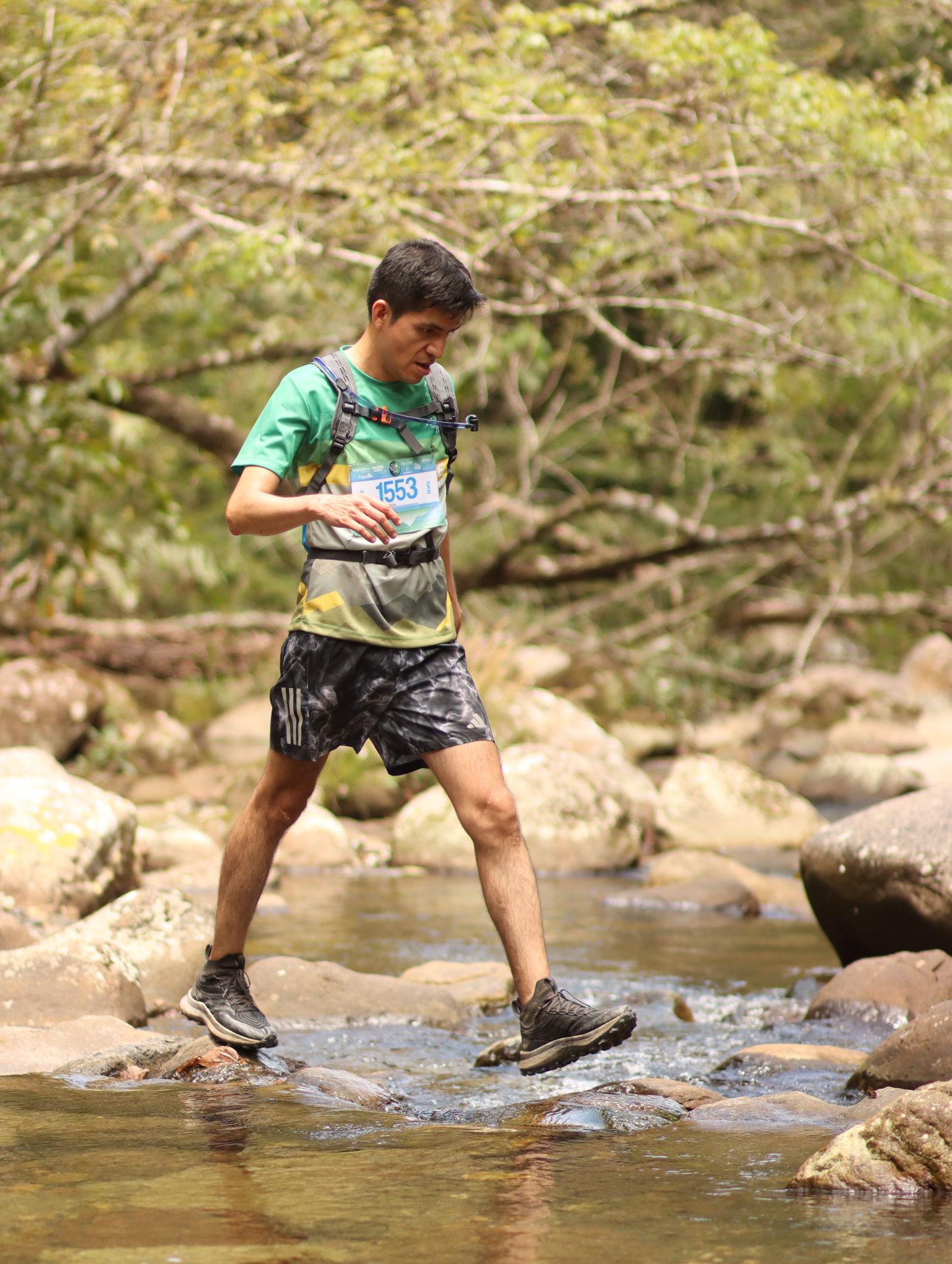 Participante del Alto Shilcayo Trail atravesando una quebrada en la Cordillera Escalera, Tarapoto